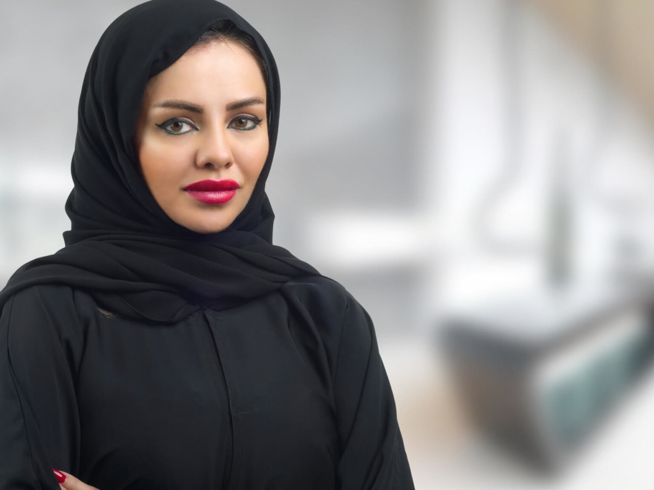 Woman wearing a black headscarf standing in an office