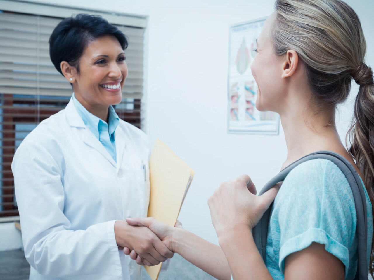 Female doctor shakes the hand of a female patient