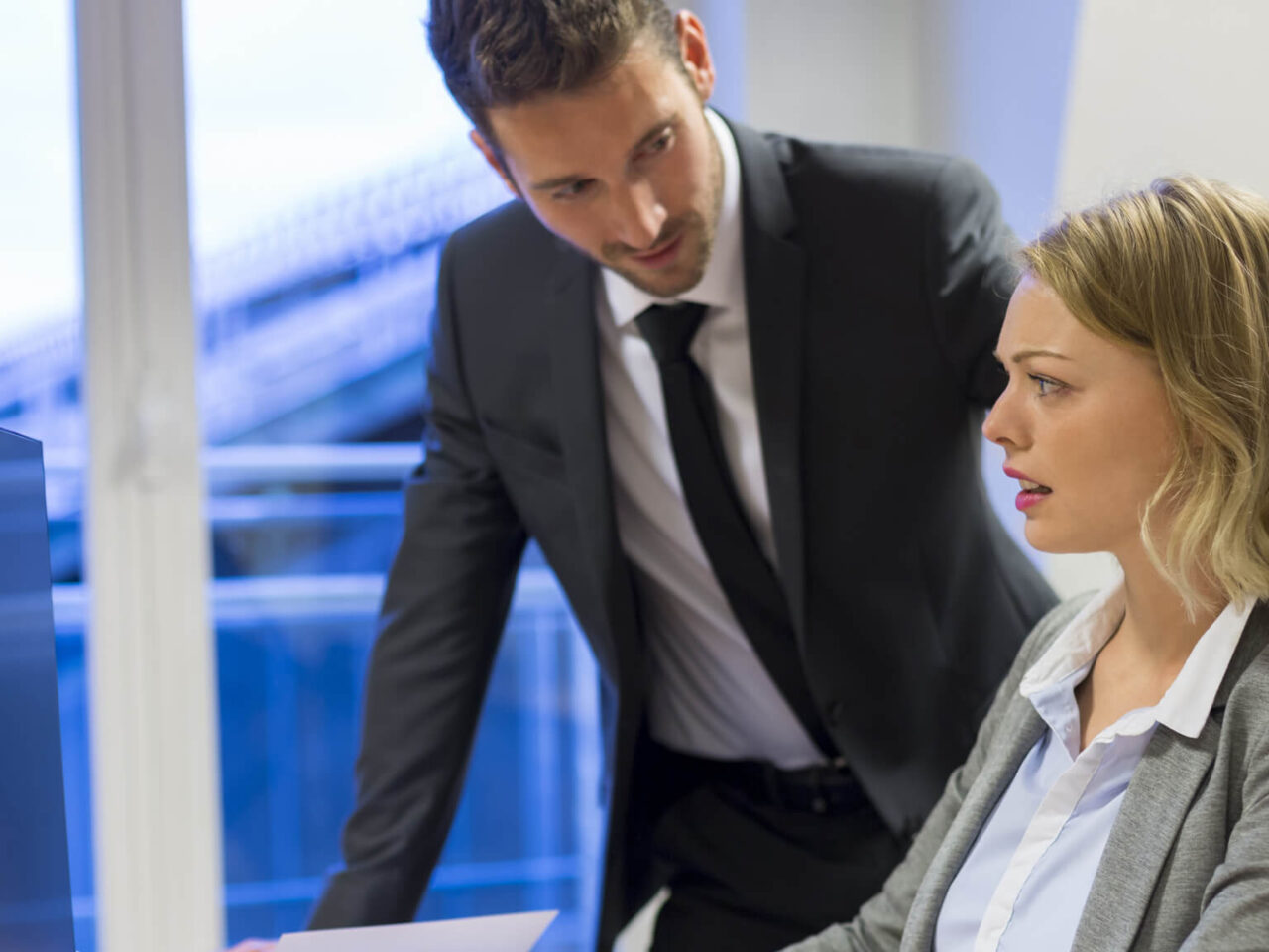 Businessman harassing a clearly uncomfortable female colleague