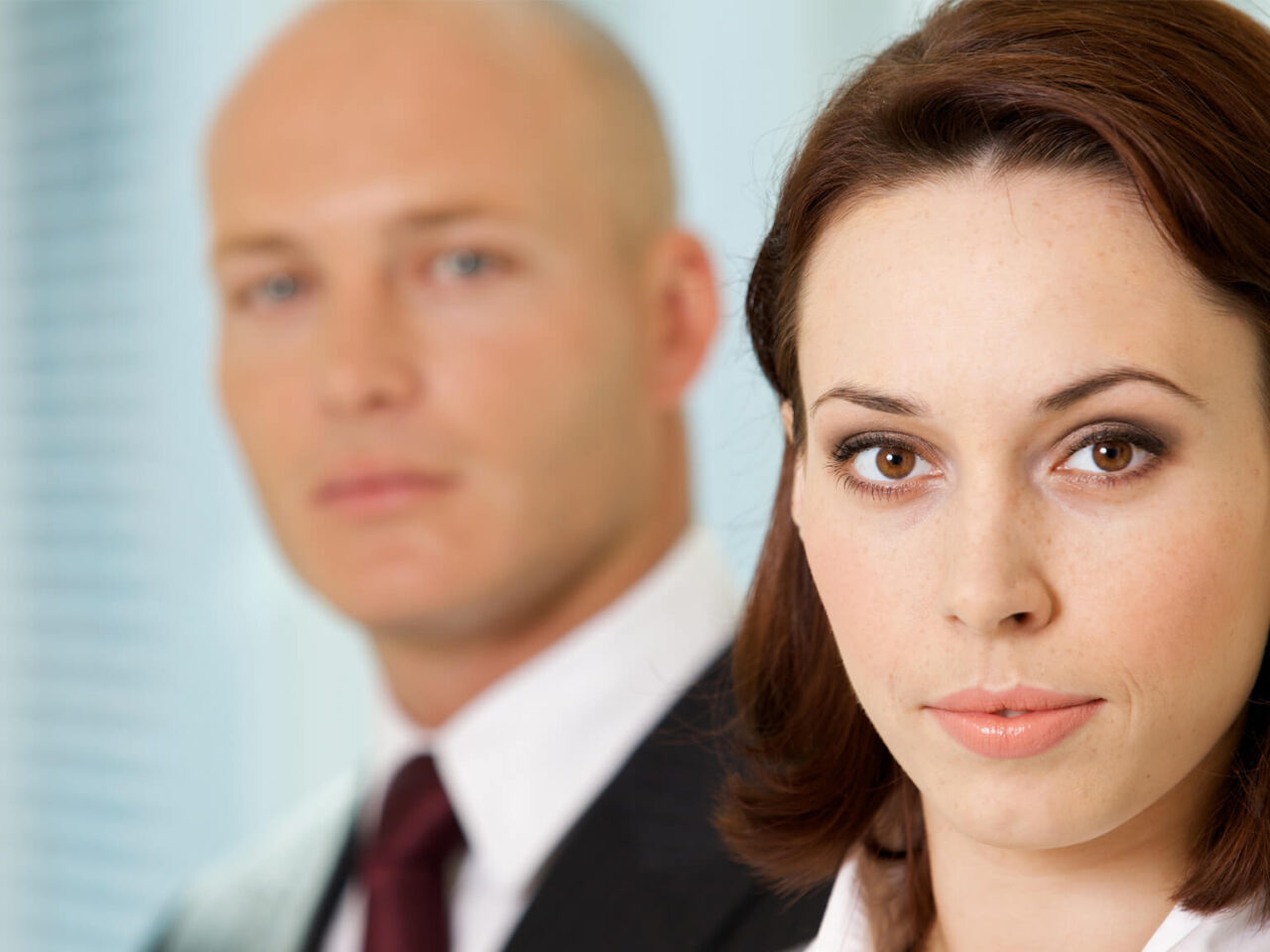 Businesswoman with a businessman staring at her from behind