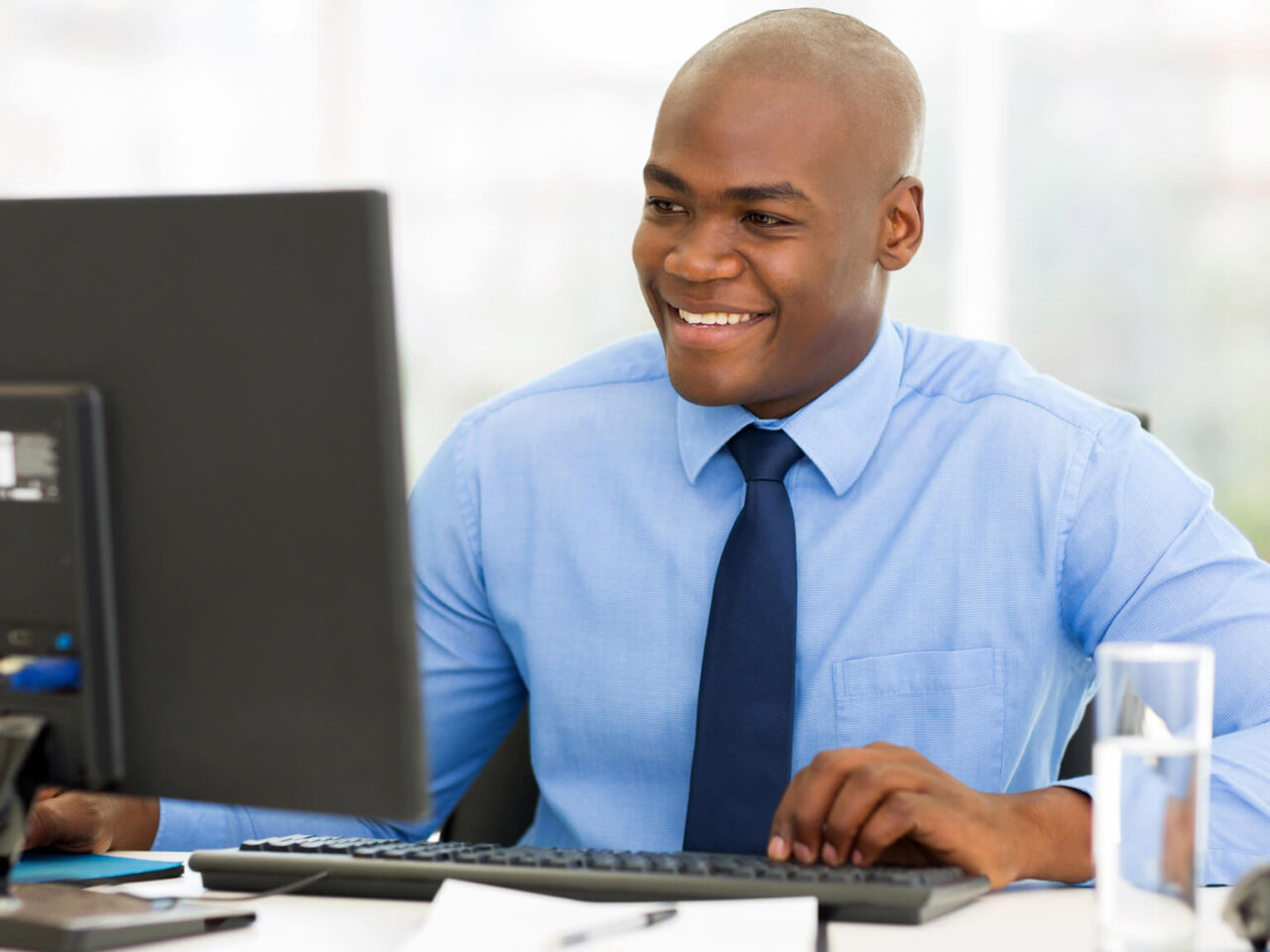 Businessman smiling and using a desktop computer