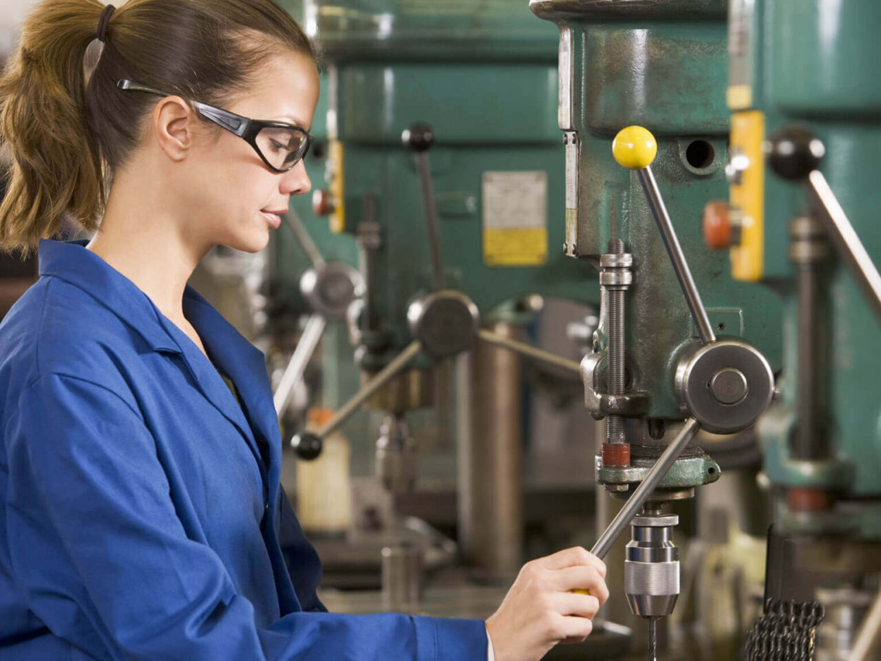 Female factory worker operating machinery
